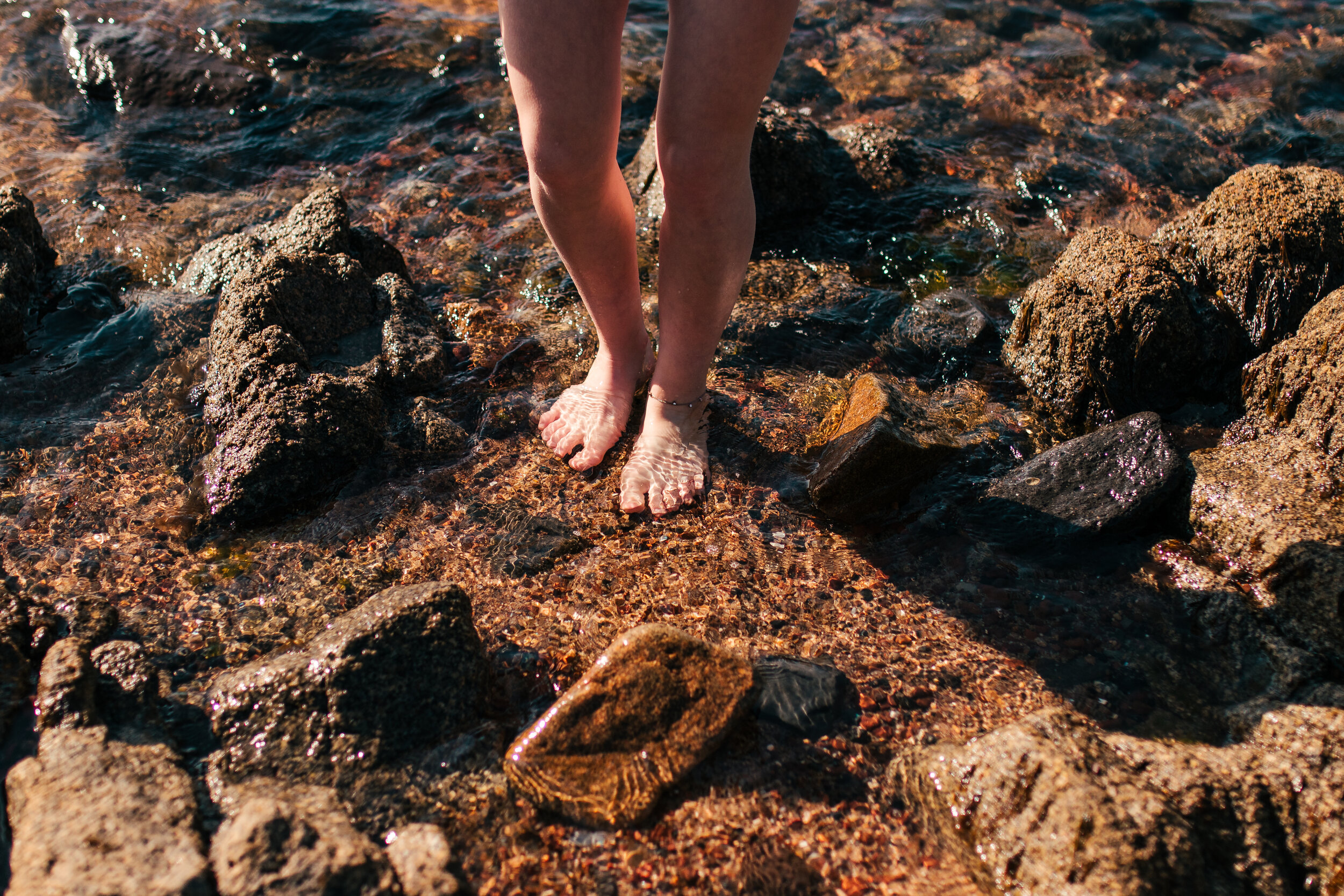 feet grounding on the rocks in the ocean at grounded.com