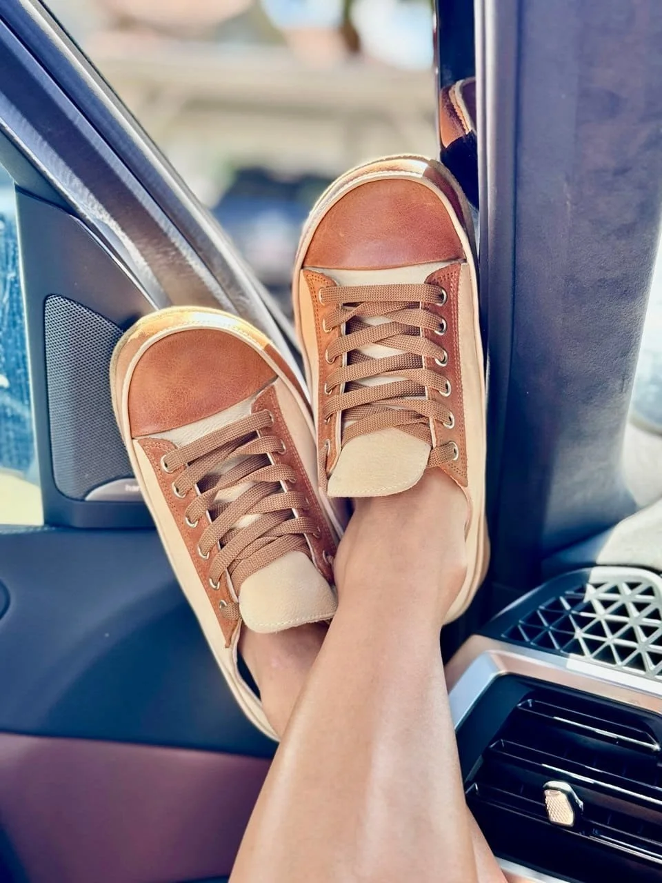 women wearing rhizal arka sneaker style grounding shoes with copper  inside a car