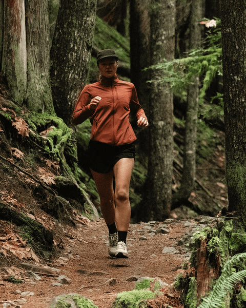 woman runs through the forest wearing bahe barefoot grounding sneakers