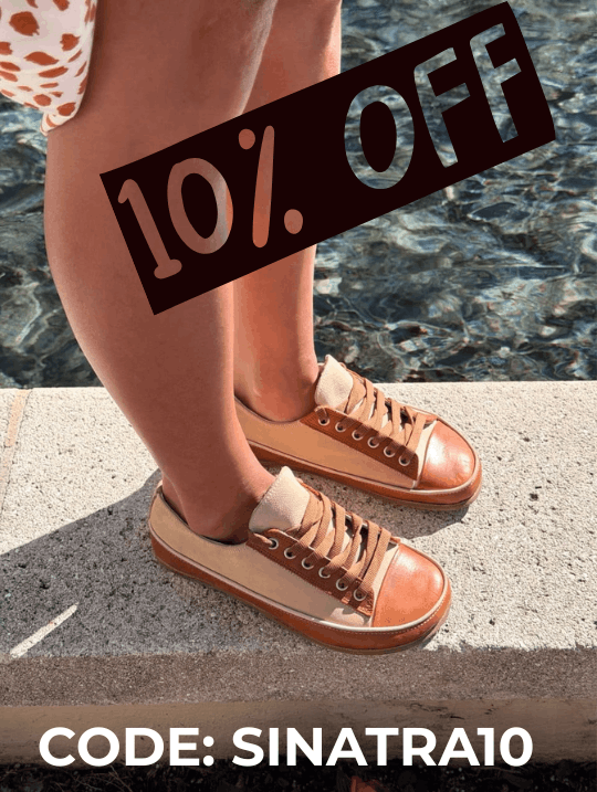 woman's legs in dress wearing Rhizal sneaker-style grounding shoes with copper next to a pool