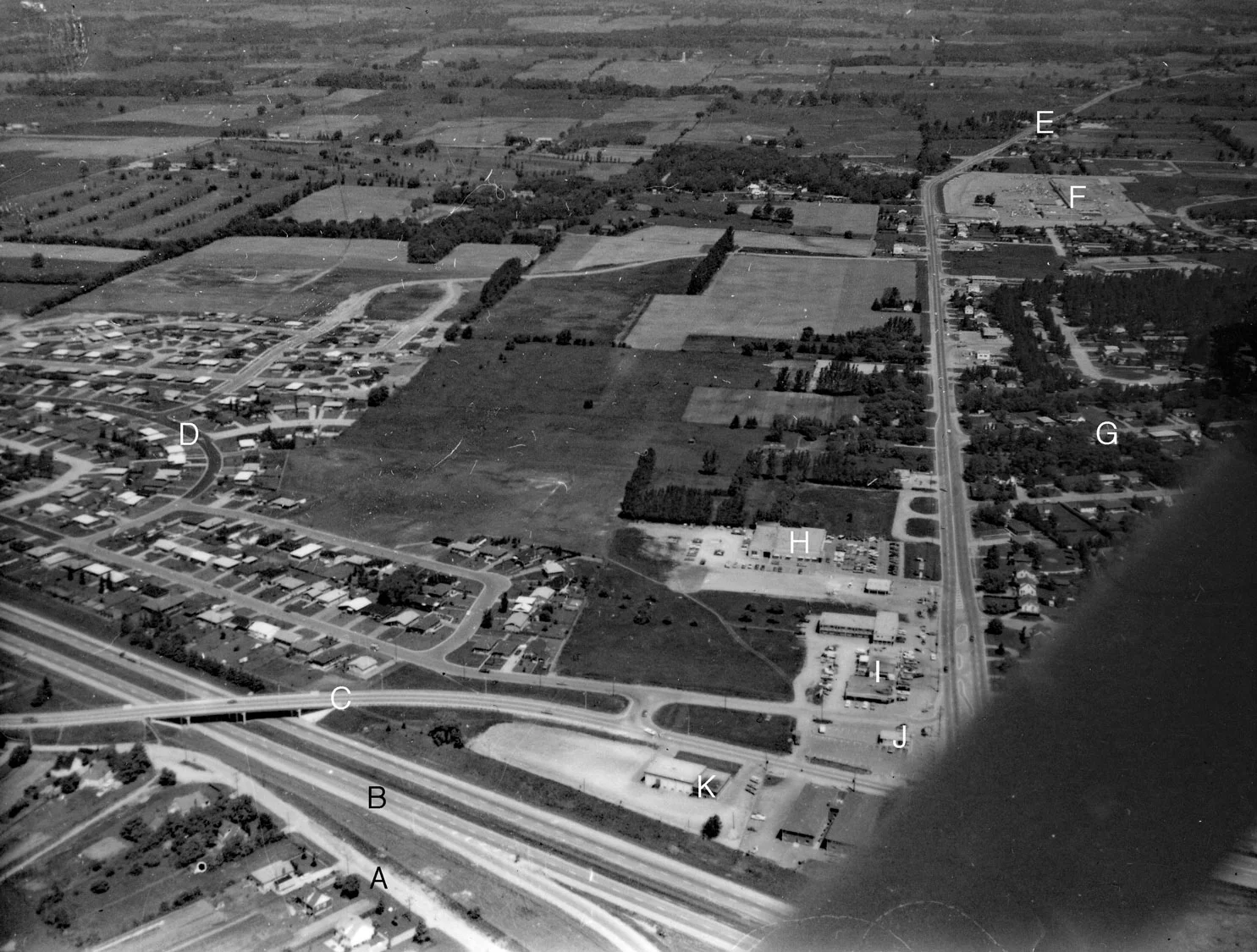 Aerial photo, Mayfair Gardens Image courtesy of the Brant Historical Society A) Barnes Avenue, B) Highway 403, C) Tollgate Road, D) Mayfair Gardens subdivision, E) Highway 24, F) Brantford Plaza, Woolco, G) Dunsdon Street, city limits, King George Road reduces to two lanes as it enters Brantford Township, H) Dingwall Motors, Mercury-Lincoln dealer, I) Farmers’ Dell Plaza, J) Dairy Queen, K) Dunsdon Legion Branch 461.