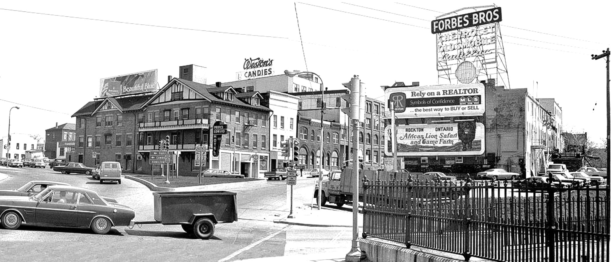 Intersection of Brant Avenue and Colborne Street. Bridge Street was open to connect Dalhousie Street traffic to Colborne Street and the Lorne Bridge. Grand River Avenue was open and connected to Greenwich Street, across the bottom go the picture. Weston’s Candies was still in business, until 1976. The Forbes Brothers sign was a landmark at the intersection. ( Image courtesy of the Brant Historical Society )