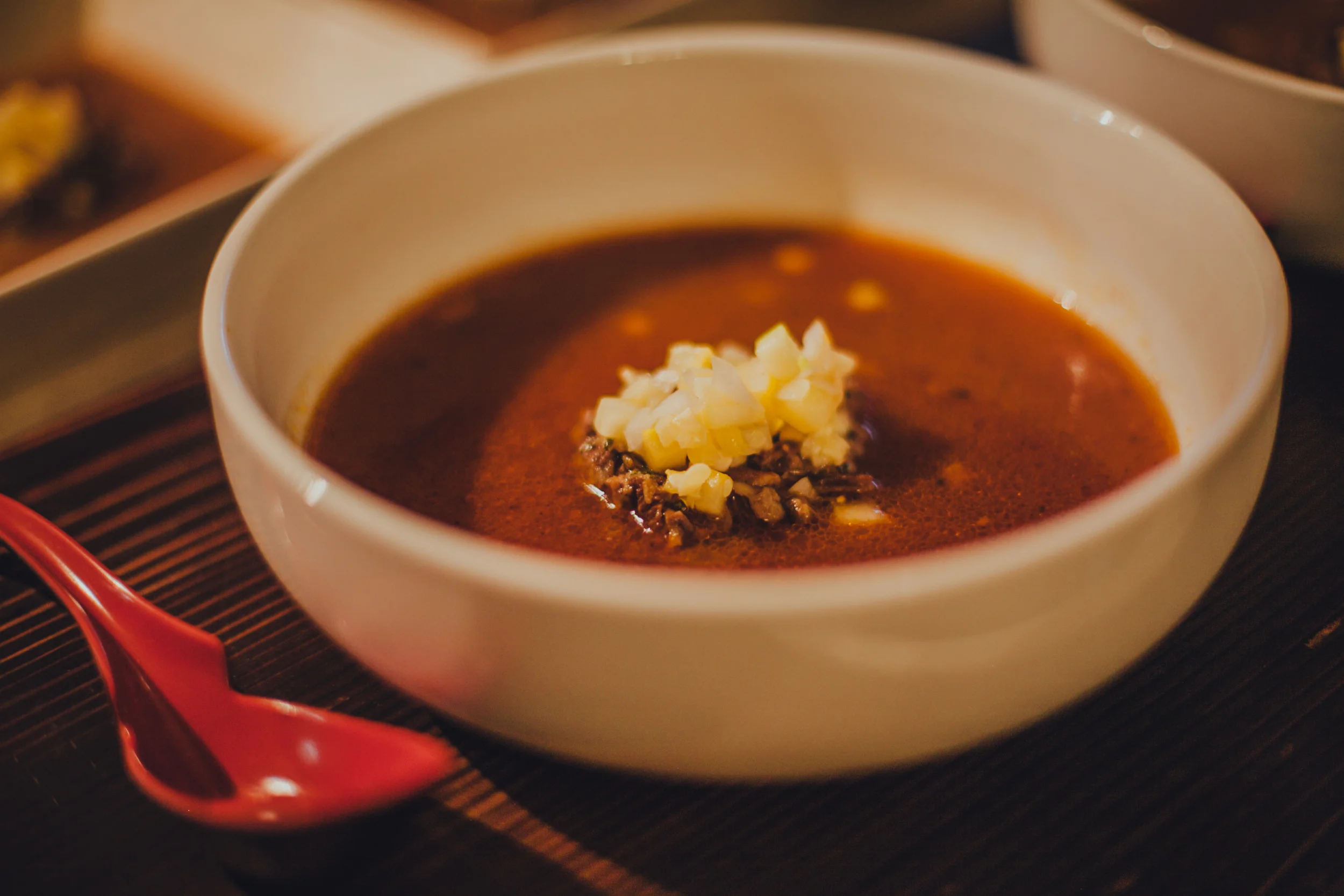 Tomato-based oxtail soup, served with diced squash, onions and zucchini.
