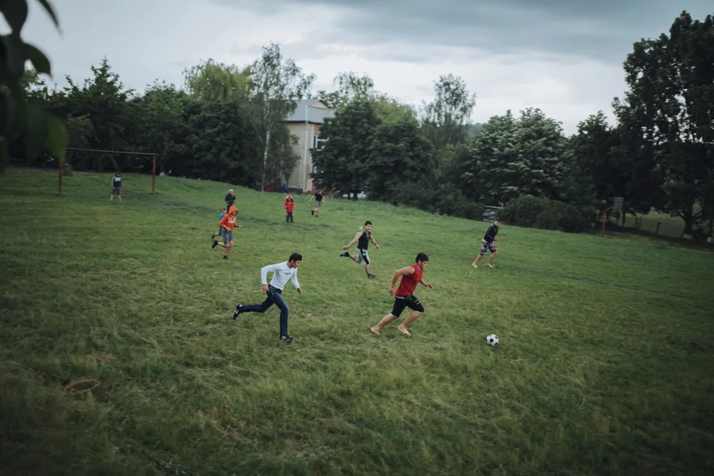 In spare time, mostly in the evenings, the guys get together to play football in the school yard. 