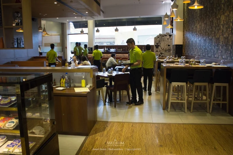 Classic wooden interiors and shades of lime green moving around at 212 All day Cafe & Bar