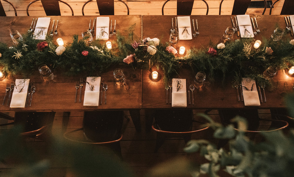  A guest table at a barn wedding reception 