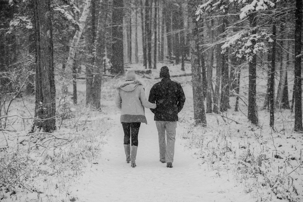  A couple walks in the woods in the snow 