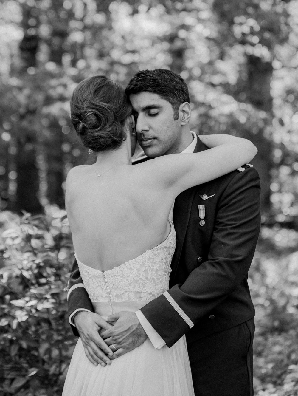  Bride and groom embrace in the woods 