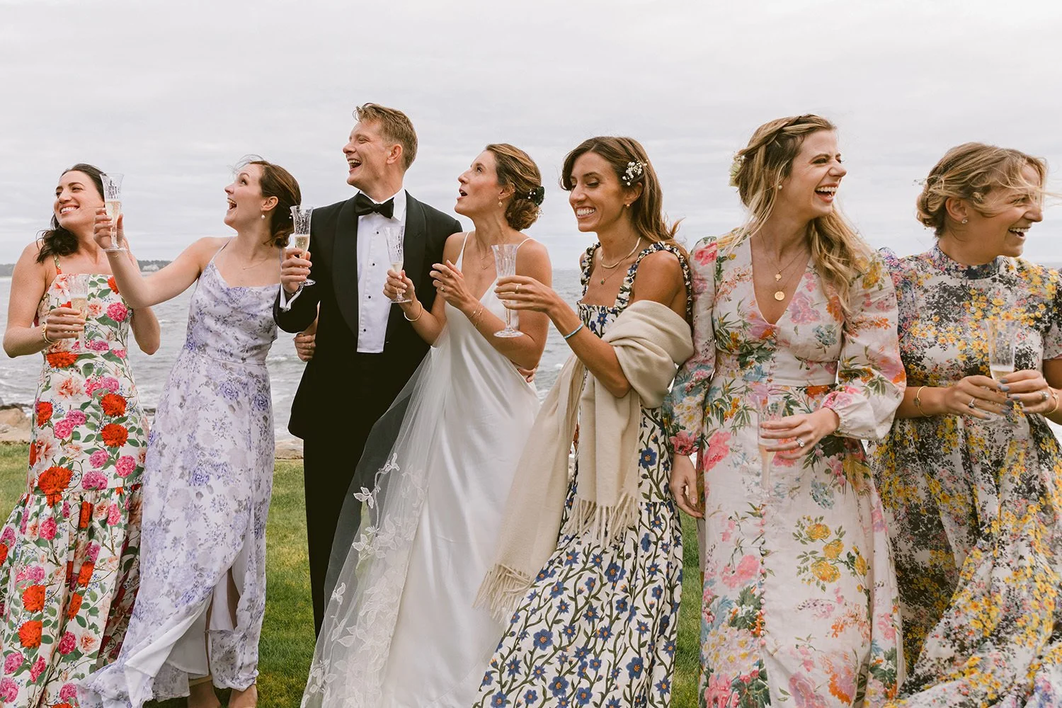 A bridal party laughing and looking up after a cork was launched into the sky