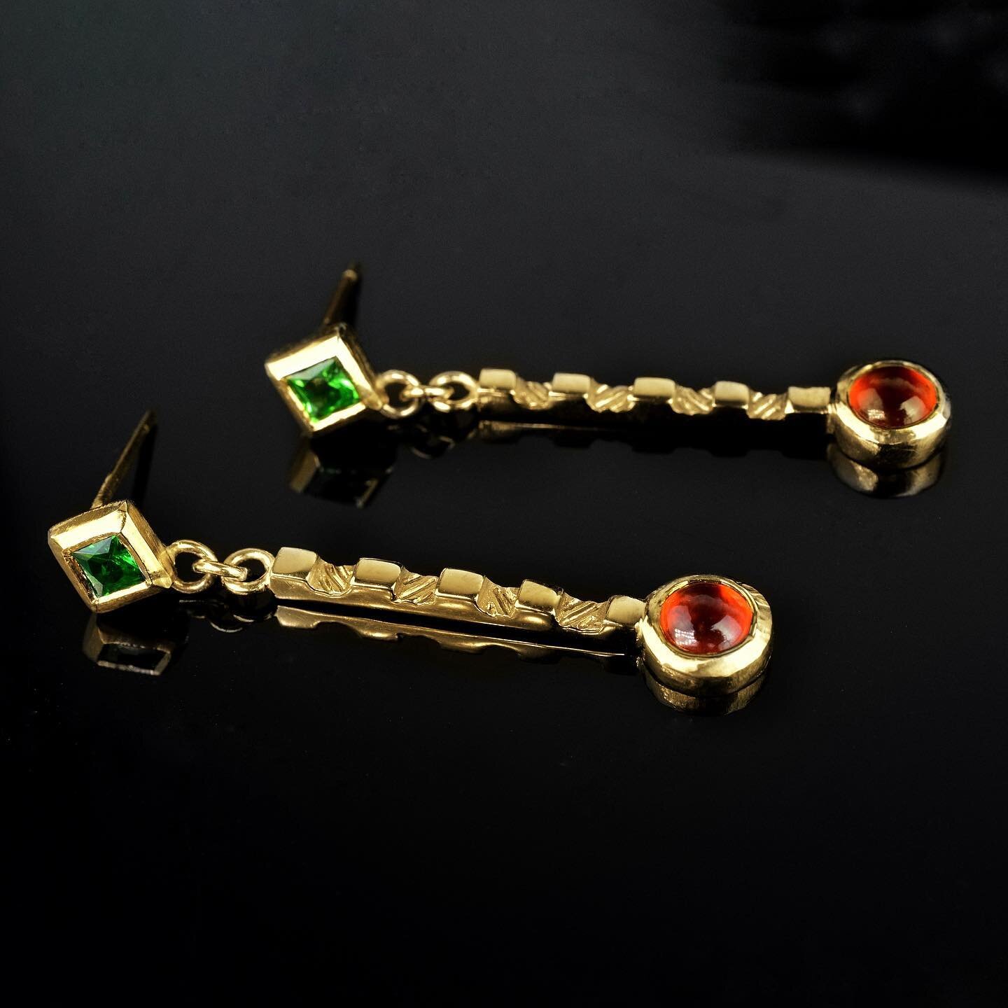 These Dynasty dangles are set with opulent green tsavorite garnets and rich fiery orange mandarin garnets In beaten gold. 

They feature hand Carved stepped pillars with contrasts of polished and engraved finishes. 

#handmade #garnetjewelry #handeng