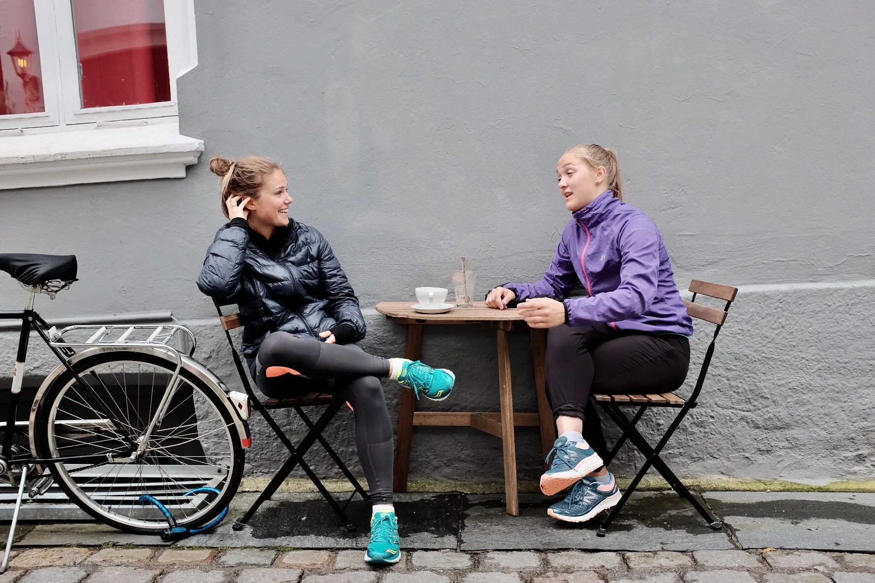 Two girls chatting it up at a local coffee joint. 