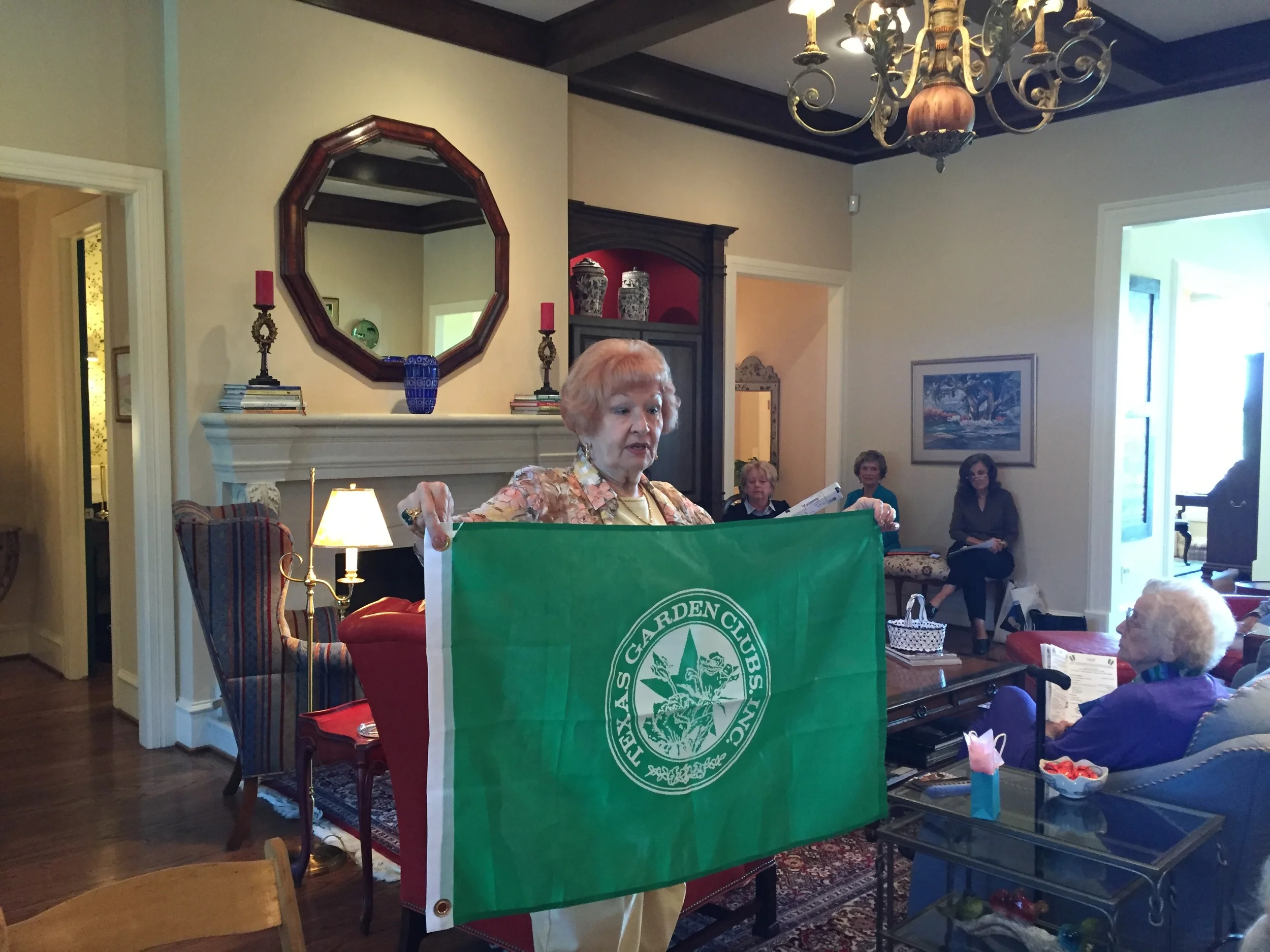 Freda Martin presents a flag she bought and donated to be placed at the Butterfly Garden.