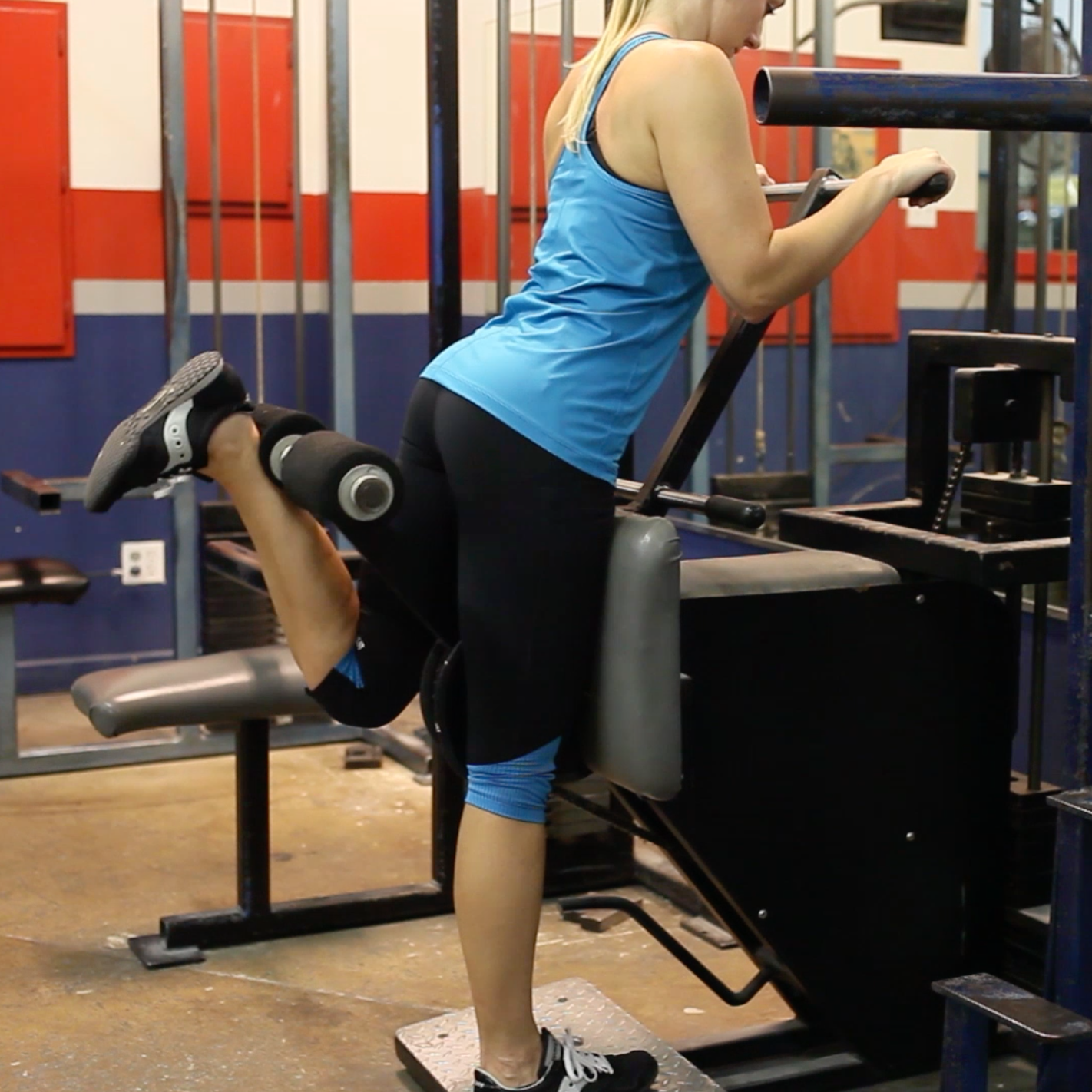 legs and glutes; demo for exercise library. standing hamstring curl machine