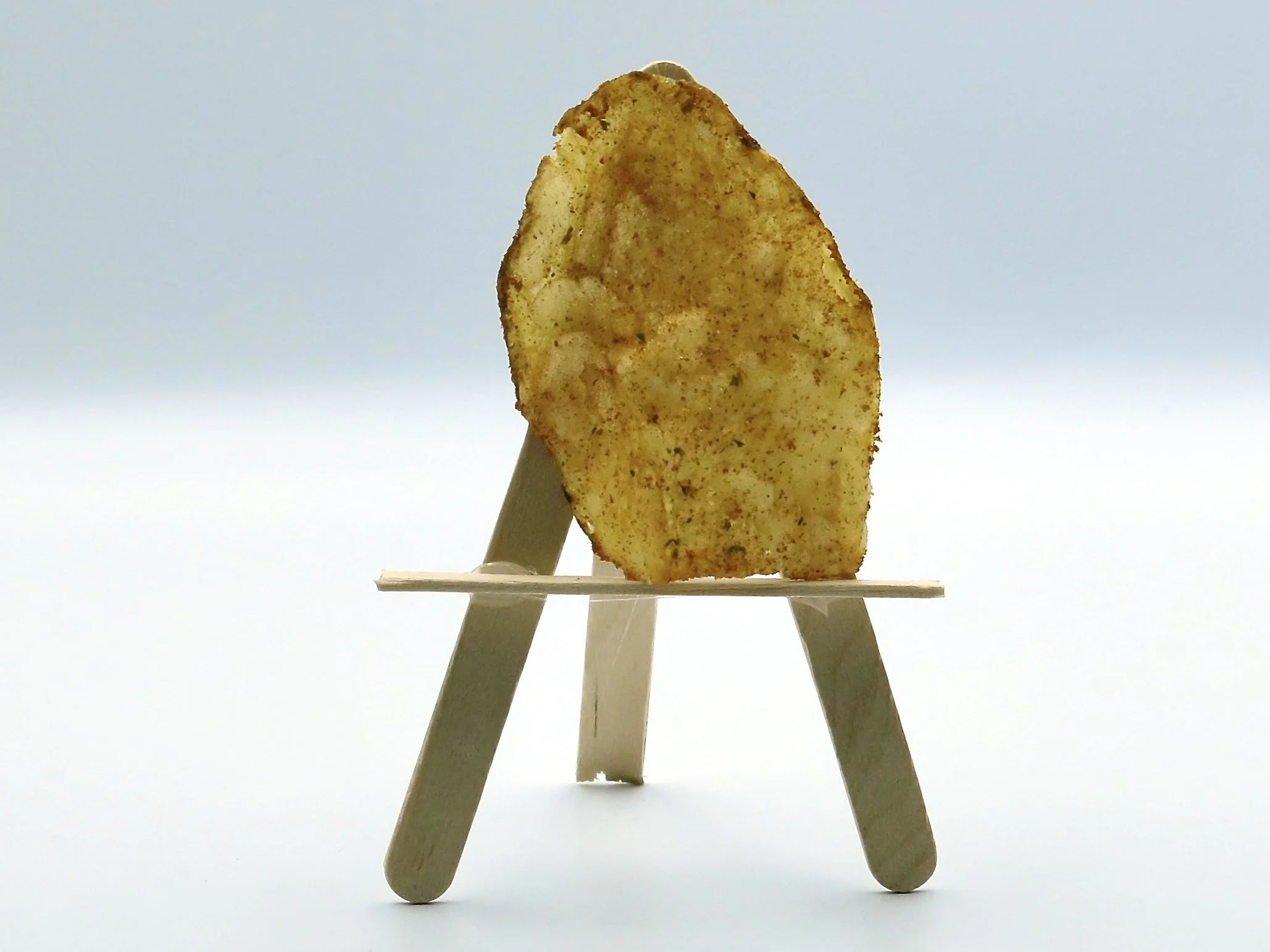 A Farm Boy Ketchup potato chip sitting on a popsicle stick easel
