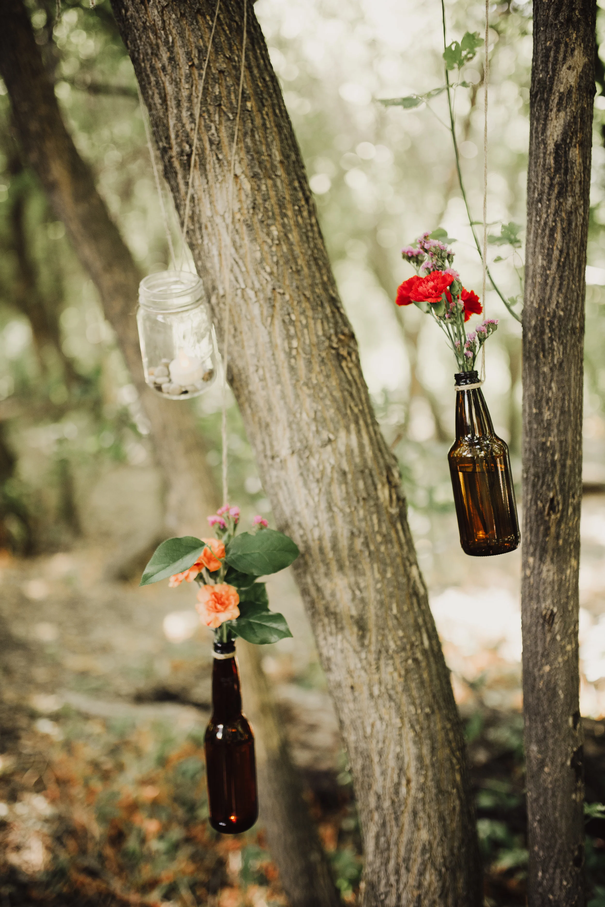 wildflowers-in-jars-hanging-from-forest-trees.jpg