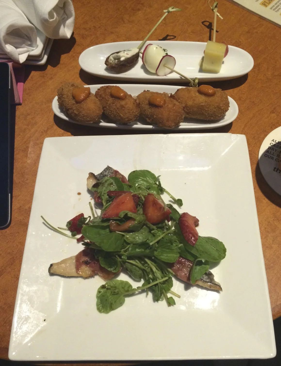Top: Fig stuffed with goat cheese skewer, quail egg and radish skewer, and manchego, rhubarb and honey skewer Middle: Croquettas with Romesco sauce Bottom: Jamón wrapped halibut with greens and strawberries
