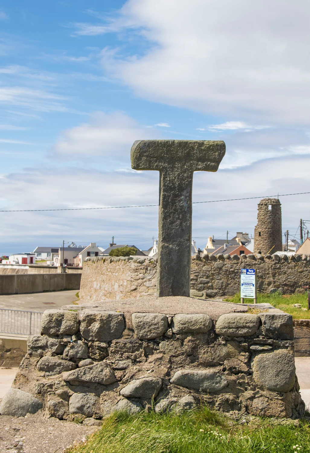 The Tau Cross and in the background, the remains of the Monastery bell tower.