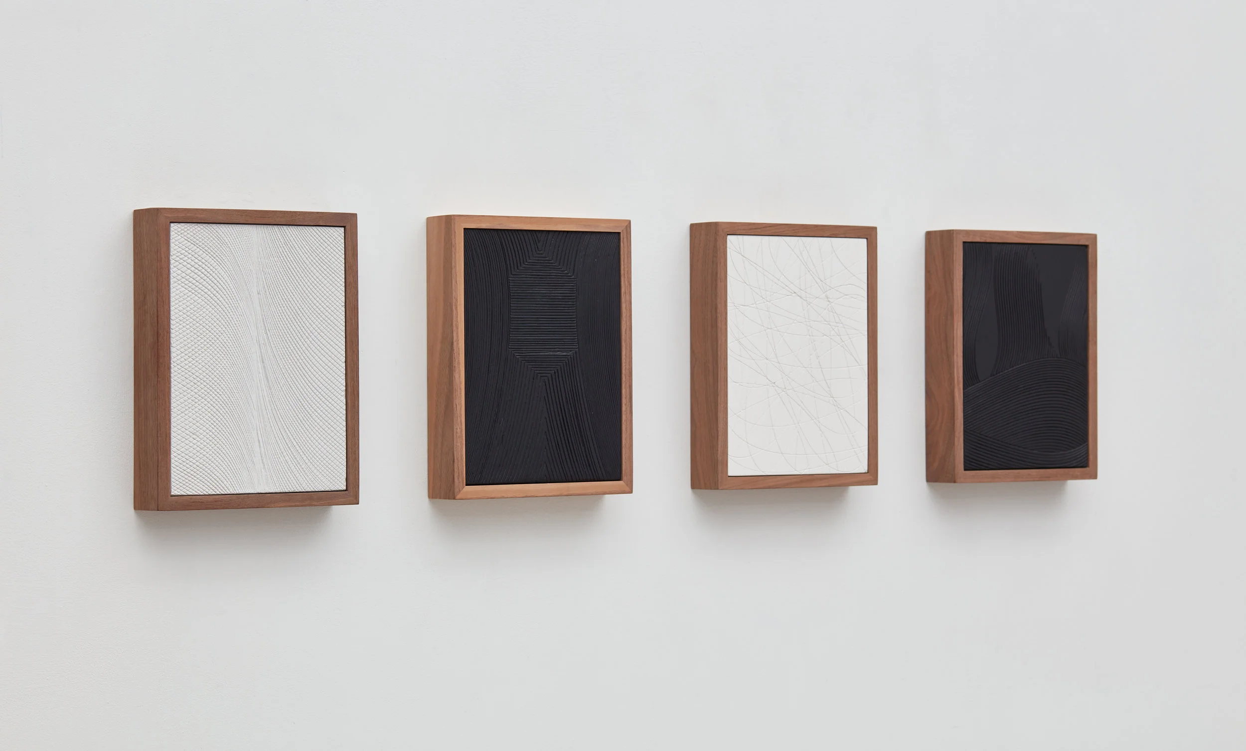 "Untitled (Four Part Etched Plaster)," (2017). Pigmented hydrocal, walnut frames. Courtesy David Kordansky Gallery.