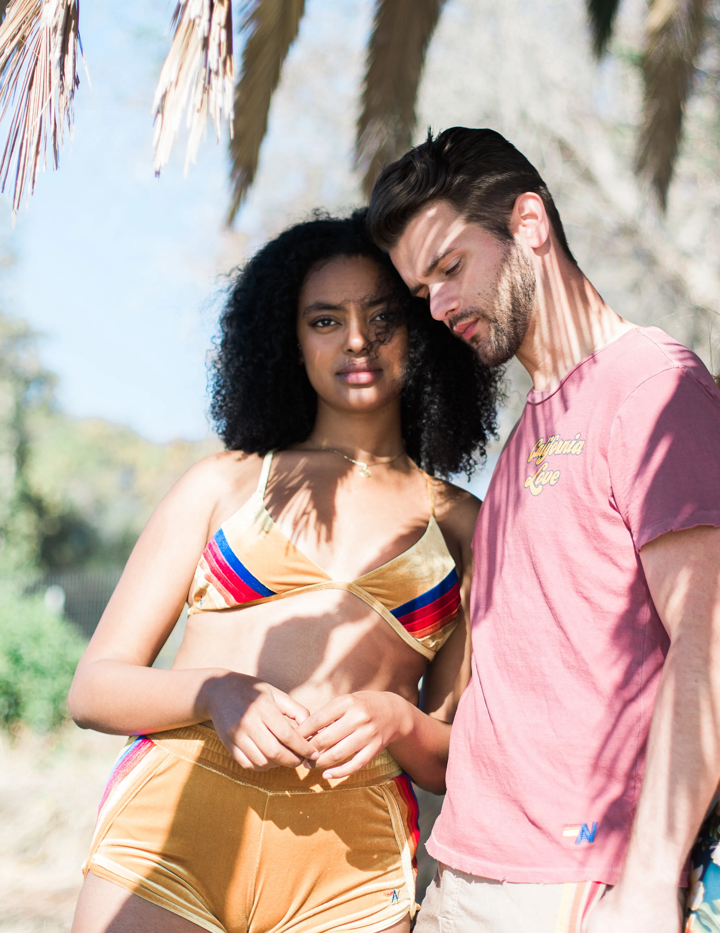 Left: Velvet Trip-Cross Bikini Top in Gold, $129; 5 Stripe Velvet Jogger Shorts in Gold, $124; Right: Small California Love Crew Tee, $83; 5 Stripe Board Shorts in Vintage Gold, $168