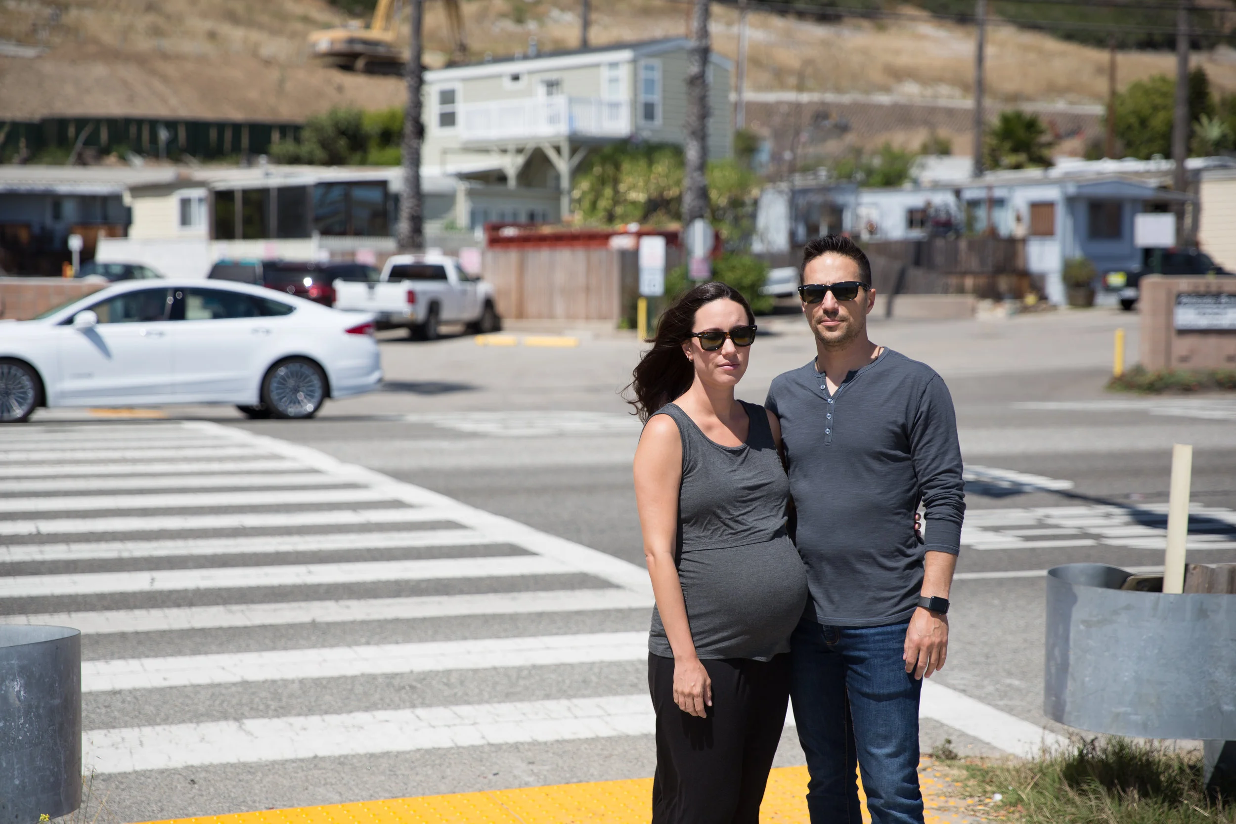 Michelle and Jon Brown stand at the crosswalk in front of the mobile home park they live in, where in 2015 Michelle and their family dog, Yogi, were tragically struck, killing Yogi and leaving Michelle with a three-inch scar on her forehead.