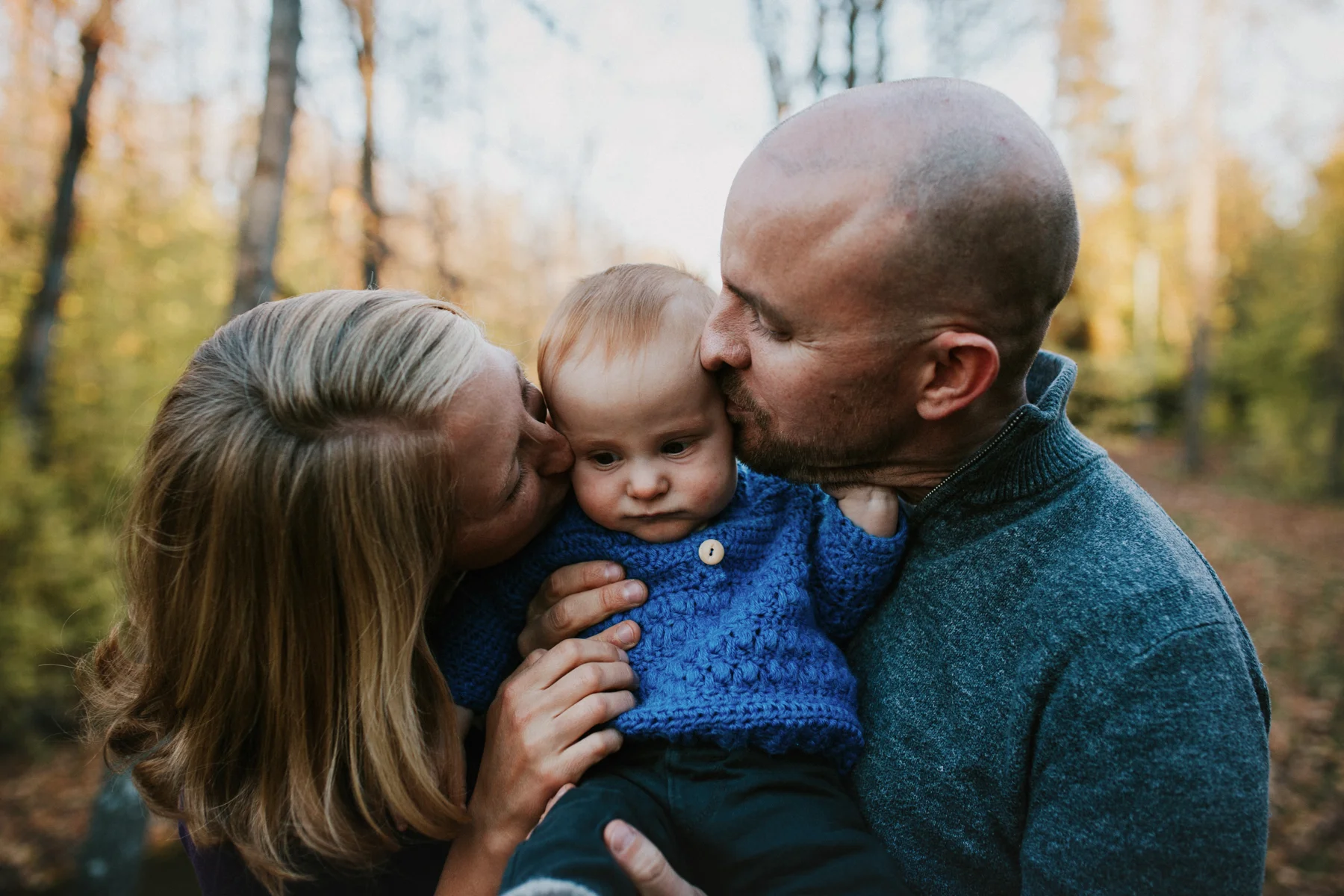 parents kissing baby in anchorage park