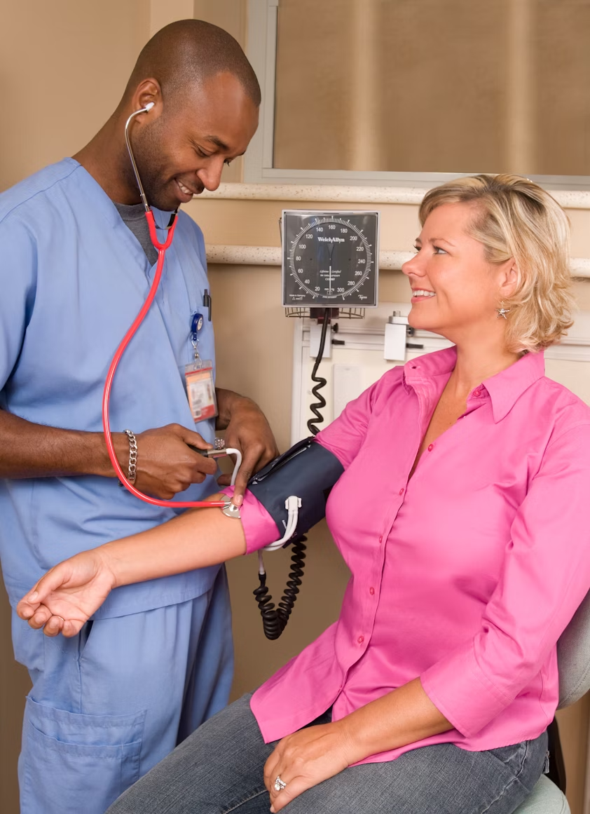 A nurse checks a patient’s blood pressure.
