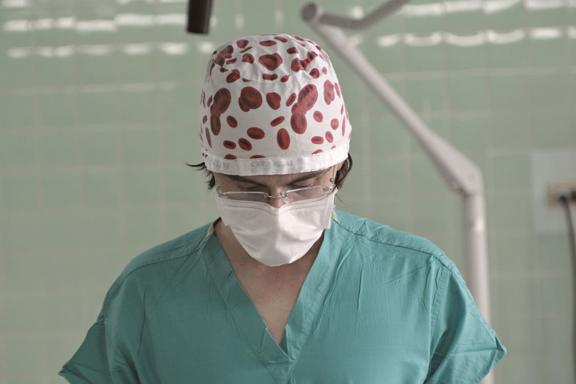 A surgeon in a printed cap.