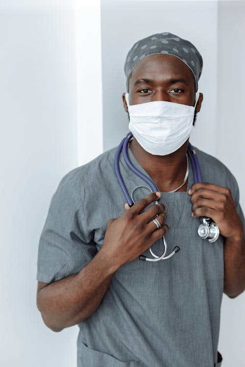 A healthcare worker wears scrubs.