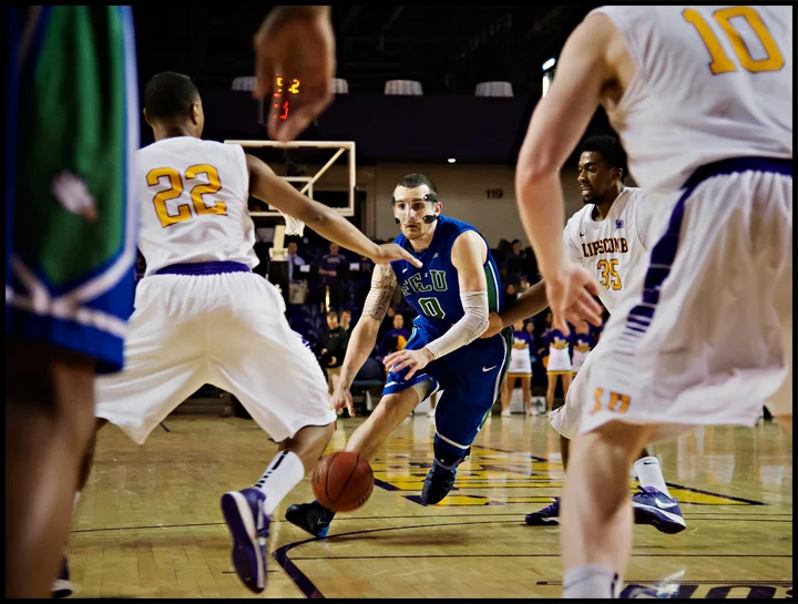 Florida Gulf Coast University's Brett Comer drives to the basket against Lipscomb University's J.C. Hampton, left, Martin Smith, back right, and Talbott Denny, front right, during their game at Lipscomb in Nashville, TN on Thursday, February 27, 2014. FGCU would fall to Lipscomb 93-71. Photos by Brian Powers