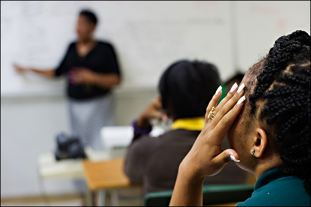 A student listens as teacher Bettye Williams describes the proper way to set up a paper for her class at H.W. Byers High School in Holly Springs, Miss. on Monday, August 11, 2014. The strict instructions are something the veteran teacher has been doing for years but says it aligns with the common core principles of following directions. Photos by Brian Powers