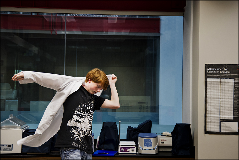  Jimmy Styers, a junior at Gatton Academy from Carlisle County Ky., puts on his lab coat before starting class on Tuesday, September 9, 2014. The class, Genome Discovery and Explorations, is a college class with a mix of Gatton and WKU students taugh