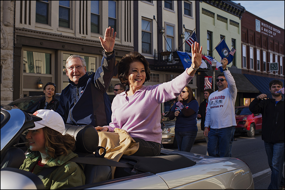  Senate minority Leader Mitch Connell, left, waves to parade watchers with his wife Elaine Chao, right, as they ride in the 50th annual Veteran's Day Parade in Madisonville, Ky. on Sunday, November 2, 2014. Brian Powers/Special to the Courier-Journal