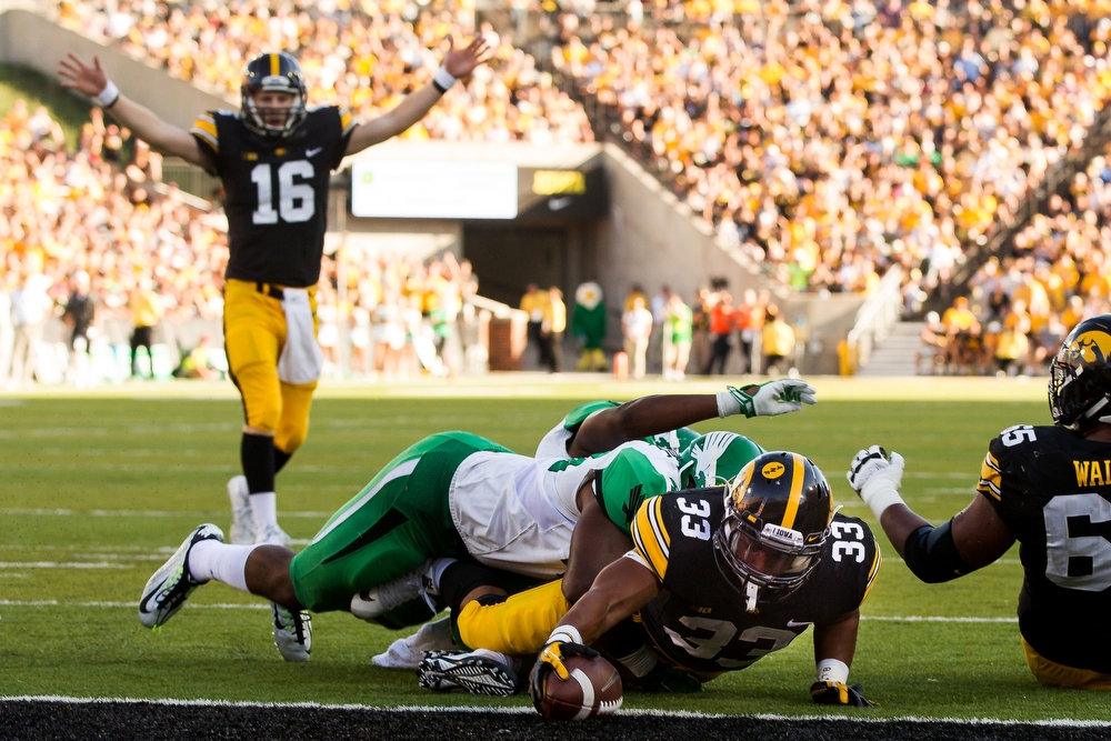  The Iowa Hawkeyes Jordan Canzeri dives for a touchdown as quarterback C.J. Boatyard celebrates in the background during their game against North Texas at home on Saturday, September 26, 2015. Iowa would go on to win 62-16. 