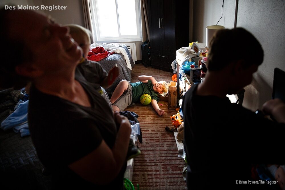  Jess Schmitt, left, and three of her sons, TJ, center, Oliver, right, and Colton, left, spend time in their room at Hotel Arthur in Glenwood where they have been living since their home outside of Pacific Junction flooded earlier this month on Wedne