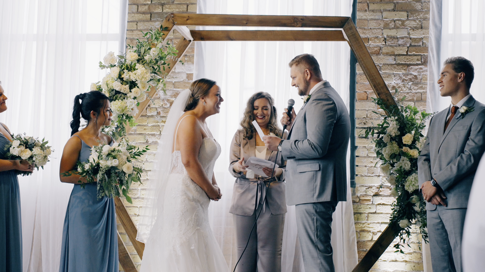 Groom reading personalizing vows and bride laughing.png