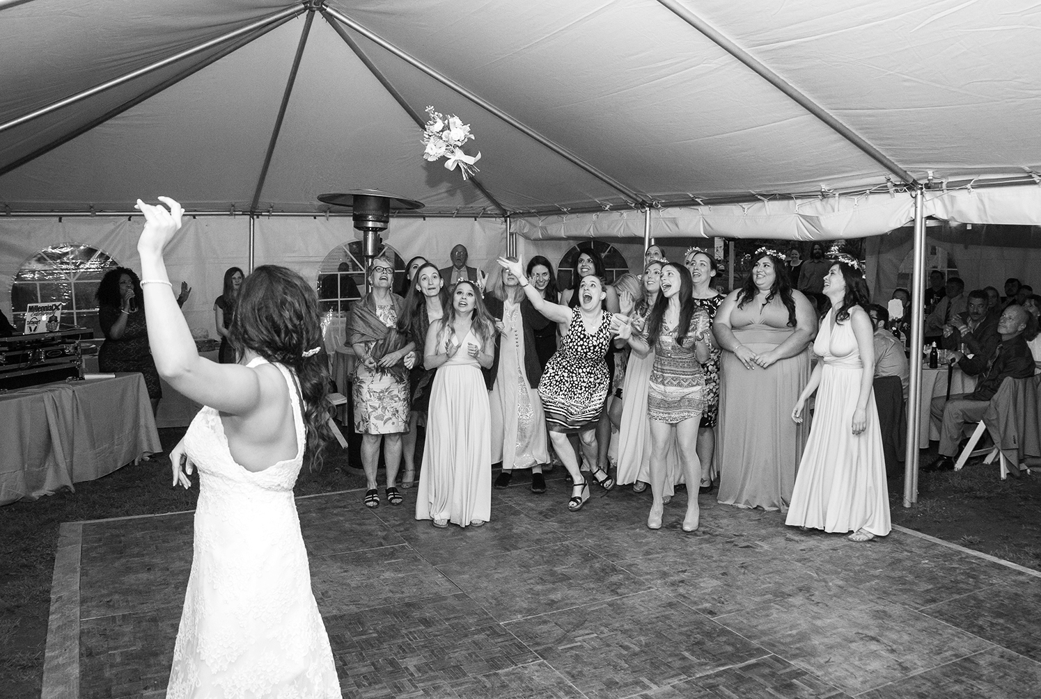 Bride throws her bouquet at Rosedale Manor tent wedding reception 