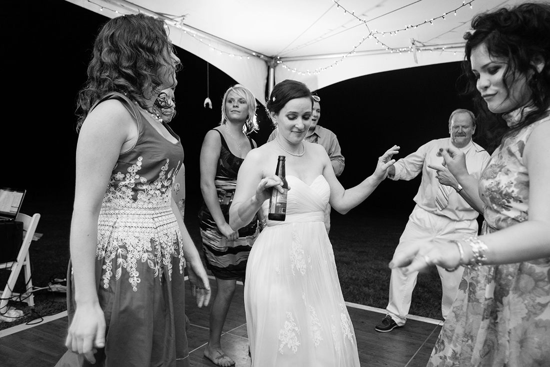 Bride and guests at tent wedding reception 
