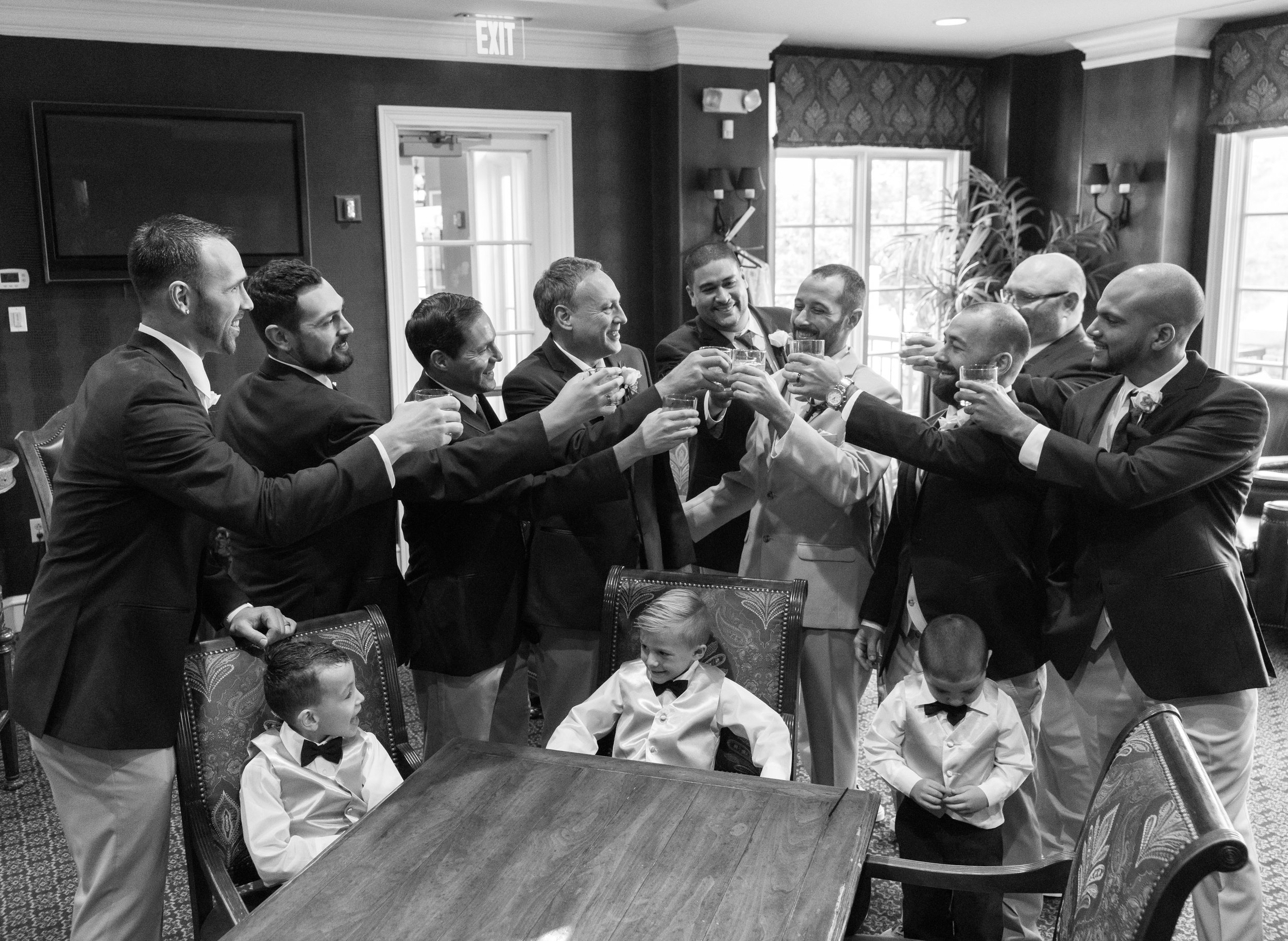 Groomsmen toasting each other in getting ready room