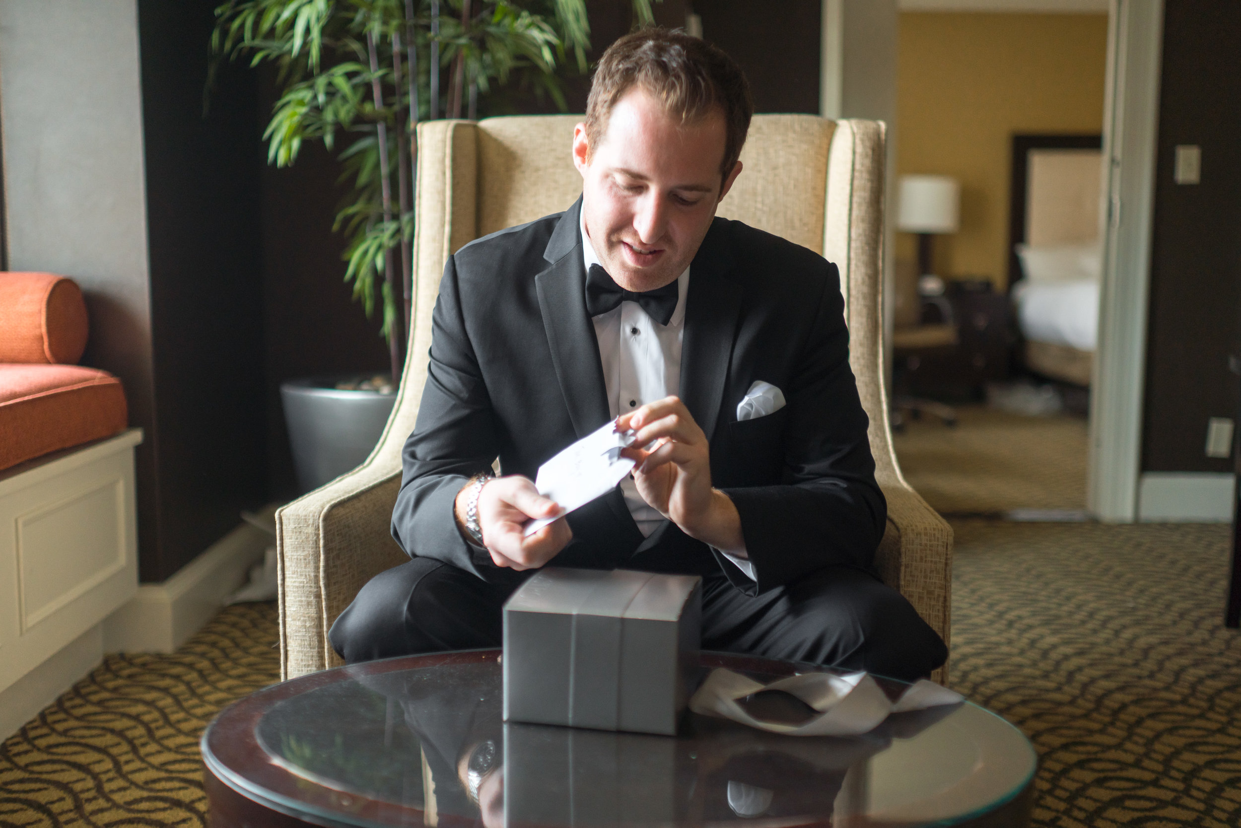 Groom at Hyatt Regency Reston receives gift from bride photos by jessica nazarova