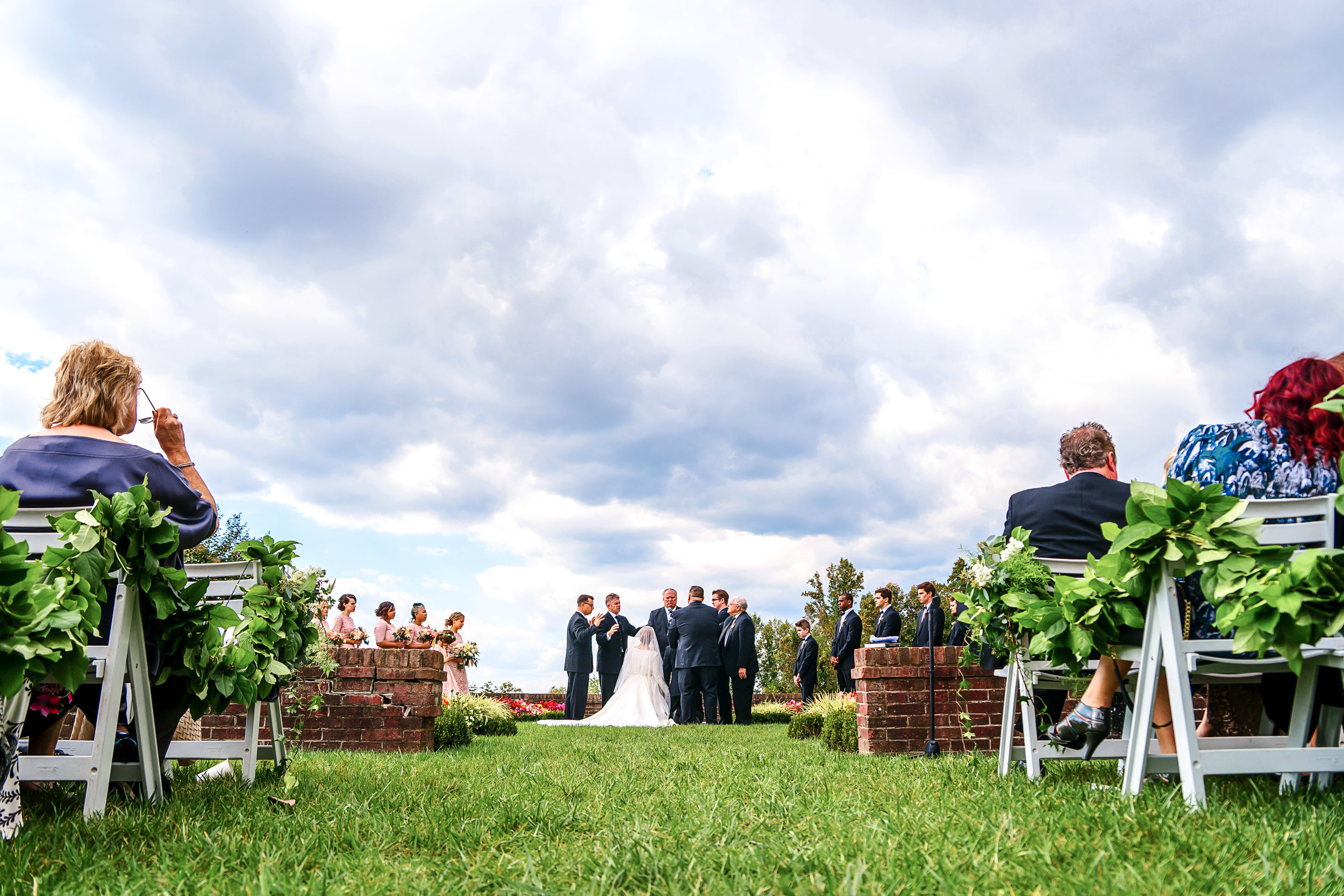 Dramatic clouds wedding ceremony photo at Oxon Hill Manor by Jessica Nazarova
