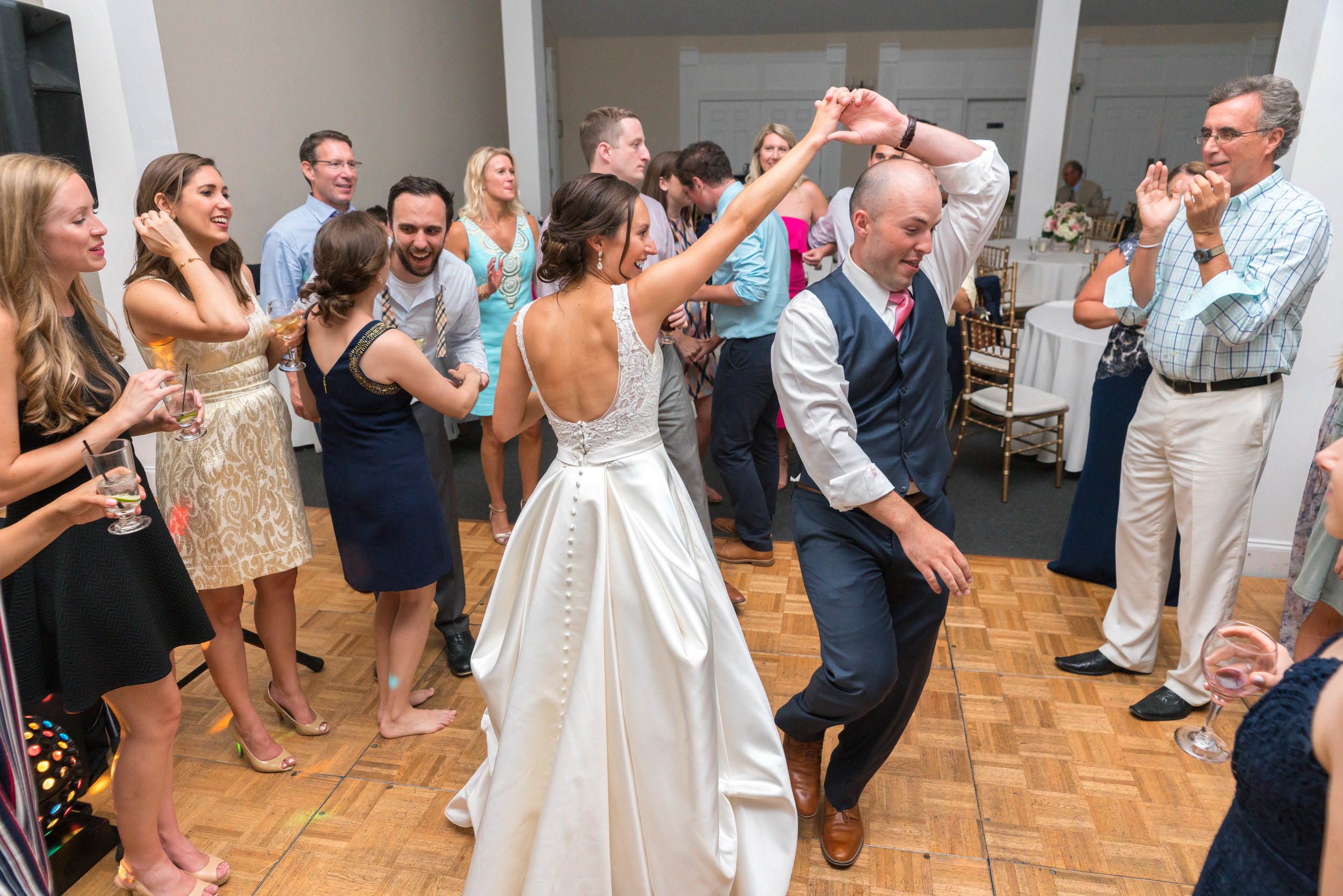 Bride and groom dancing in a group at Springfield Manor Winery