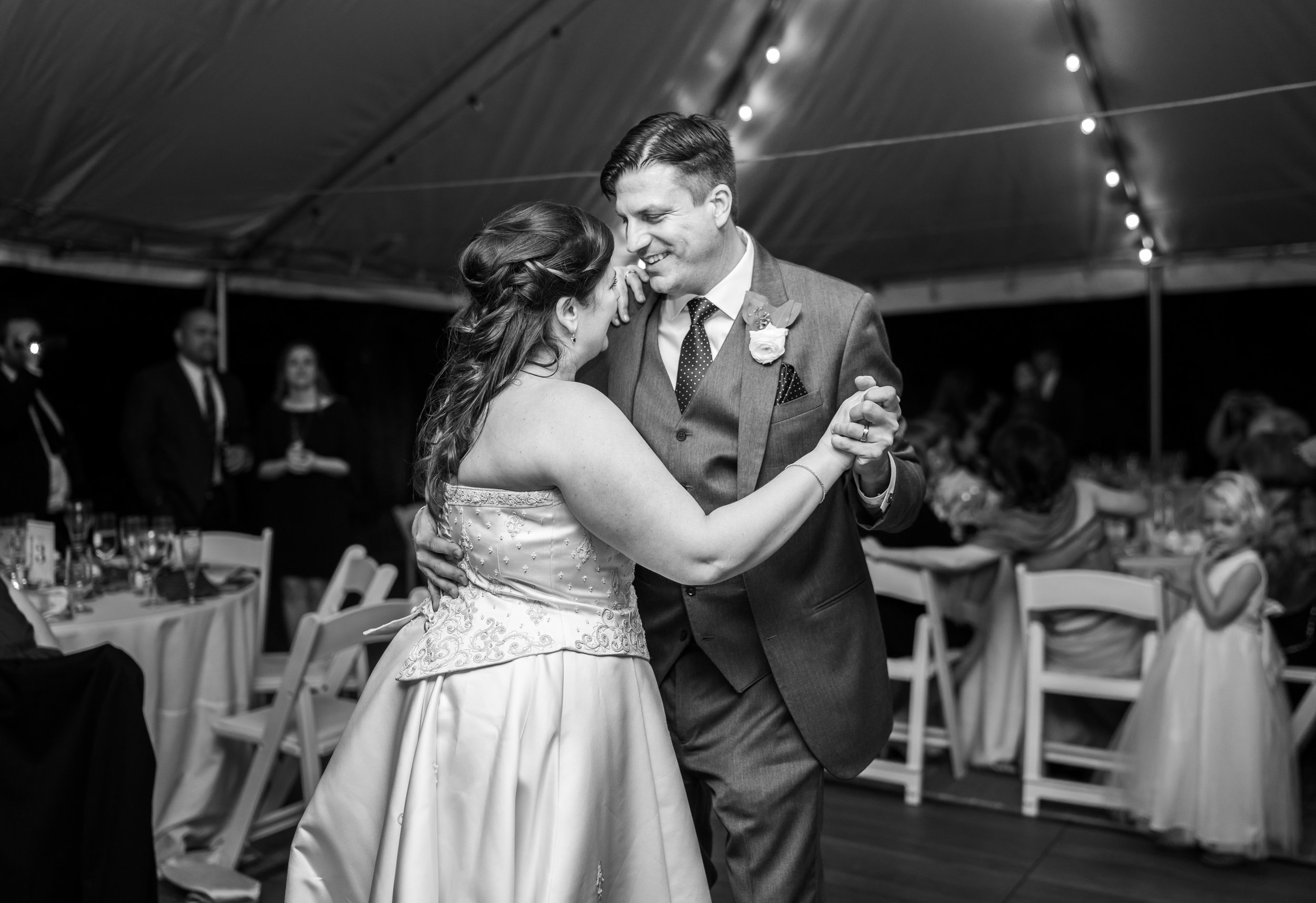 Black and white photo of bride and groom sharing their first dance under a tent at Hendry House