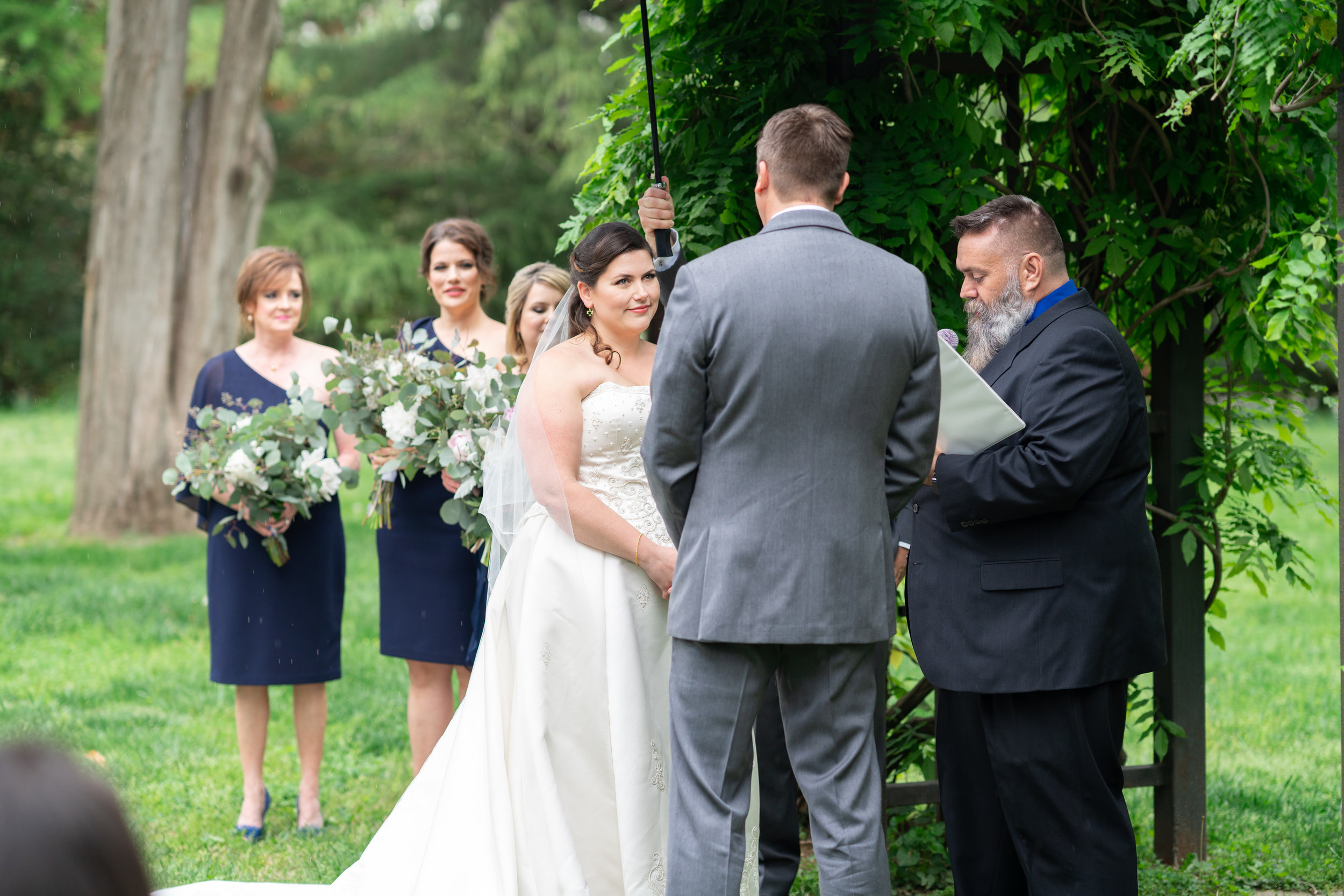 Ceremony under an ivy arch at Hendry House wedding