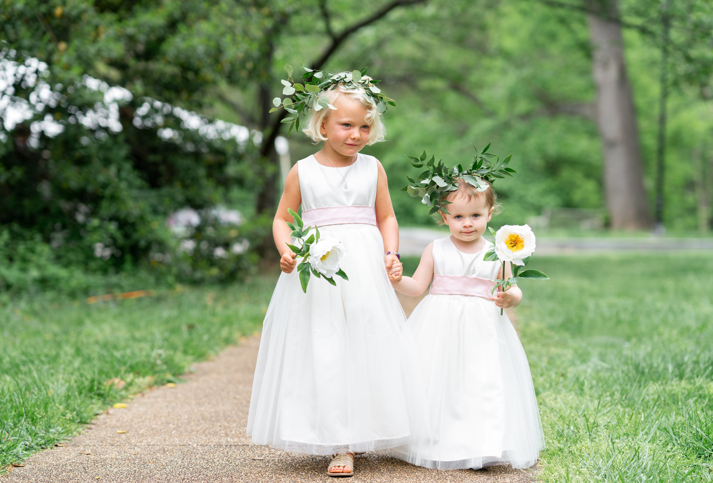 Flower girls in flower crowns walking down the aisle at Hendry house wedding