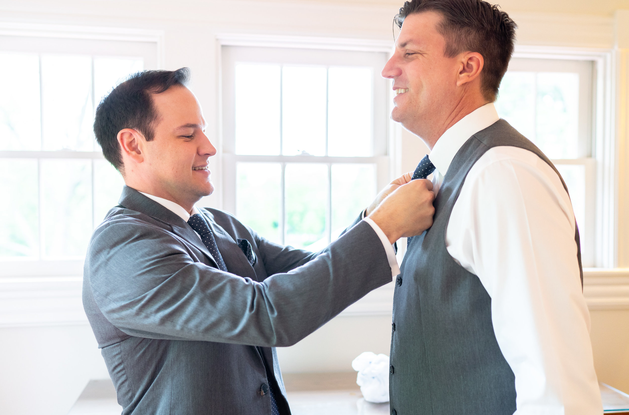Groomsmen tying bow tie at Hendry House wedding