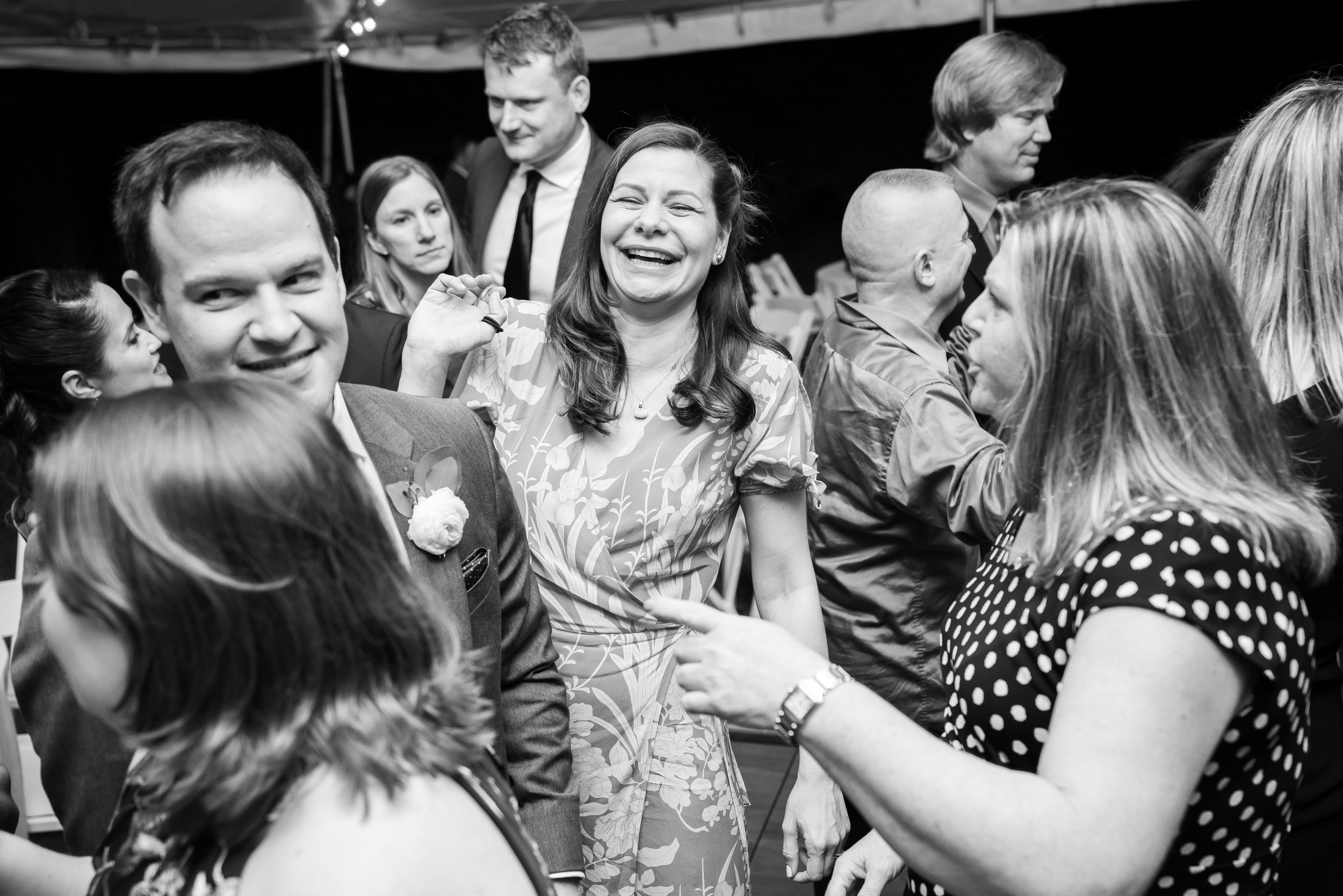 Black and white photo of wedding guests laughing on the dance at Hendry House