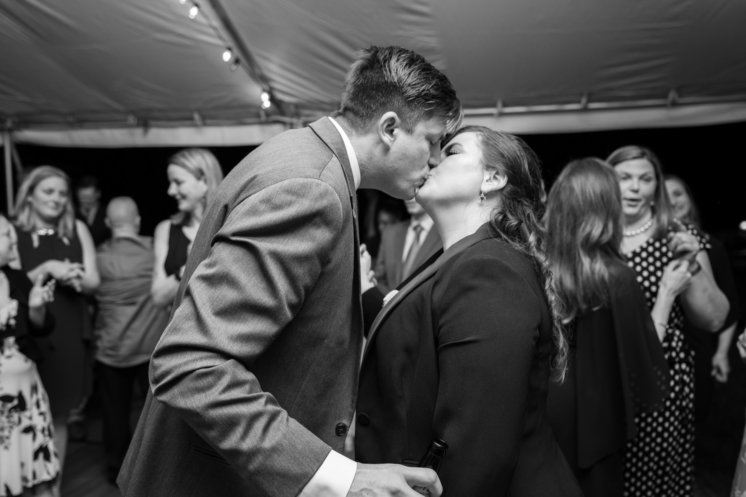 Black and white photo of bride and groom sharing their last kiss of the night at Hendry House wedding