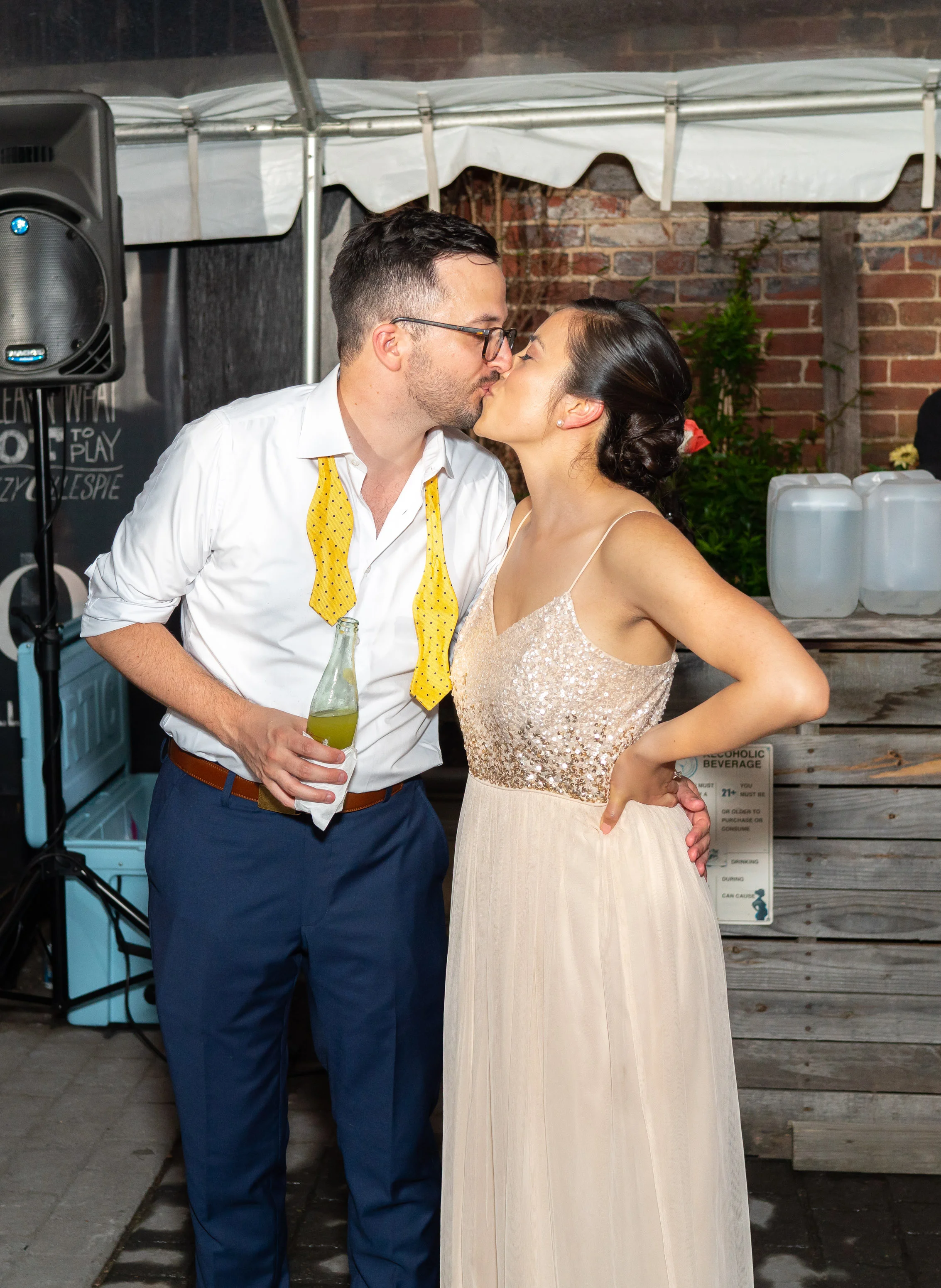 Bride and groom share a kiss in front of their cake at wedding venue Gallery OonH