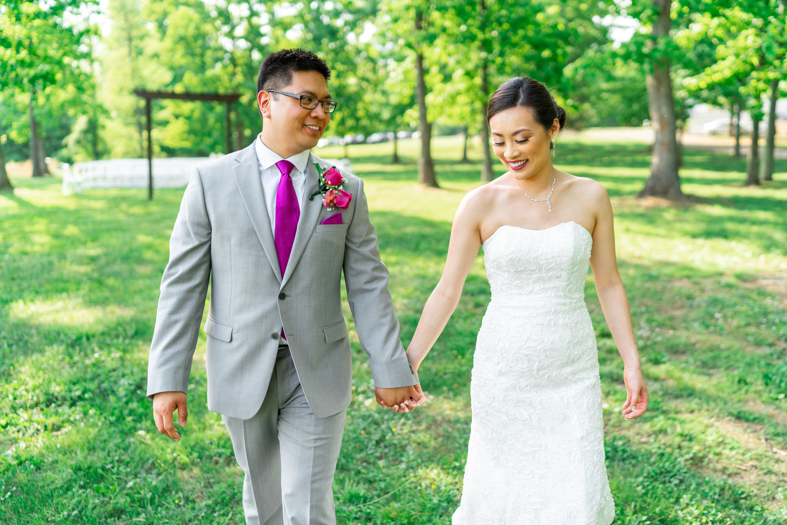 Bride and groom walking and holding hands smiling