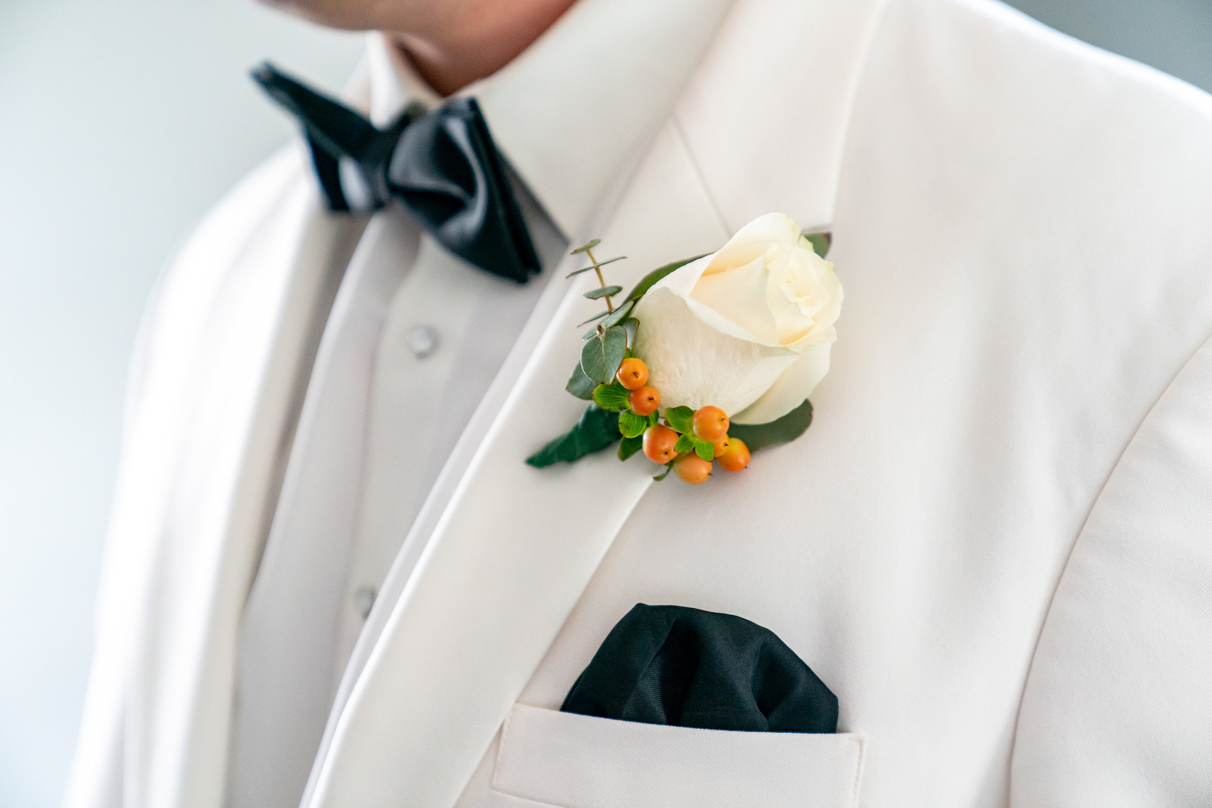White groom's tux and white rose boutonniere at Lost Creek Winery wedding